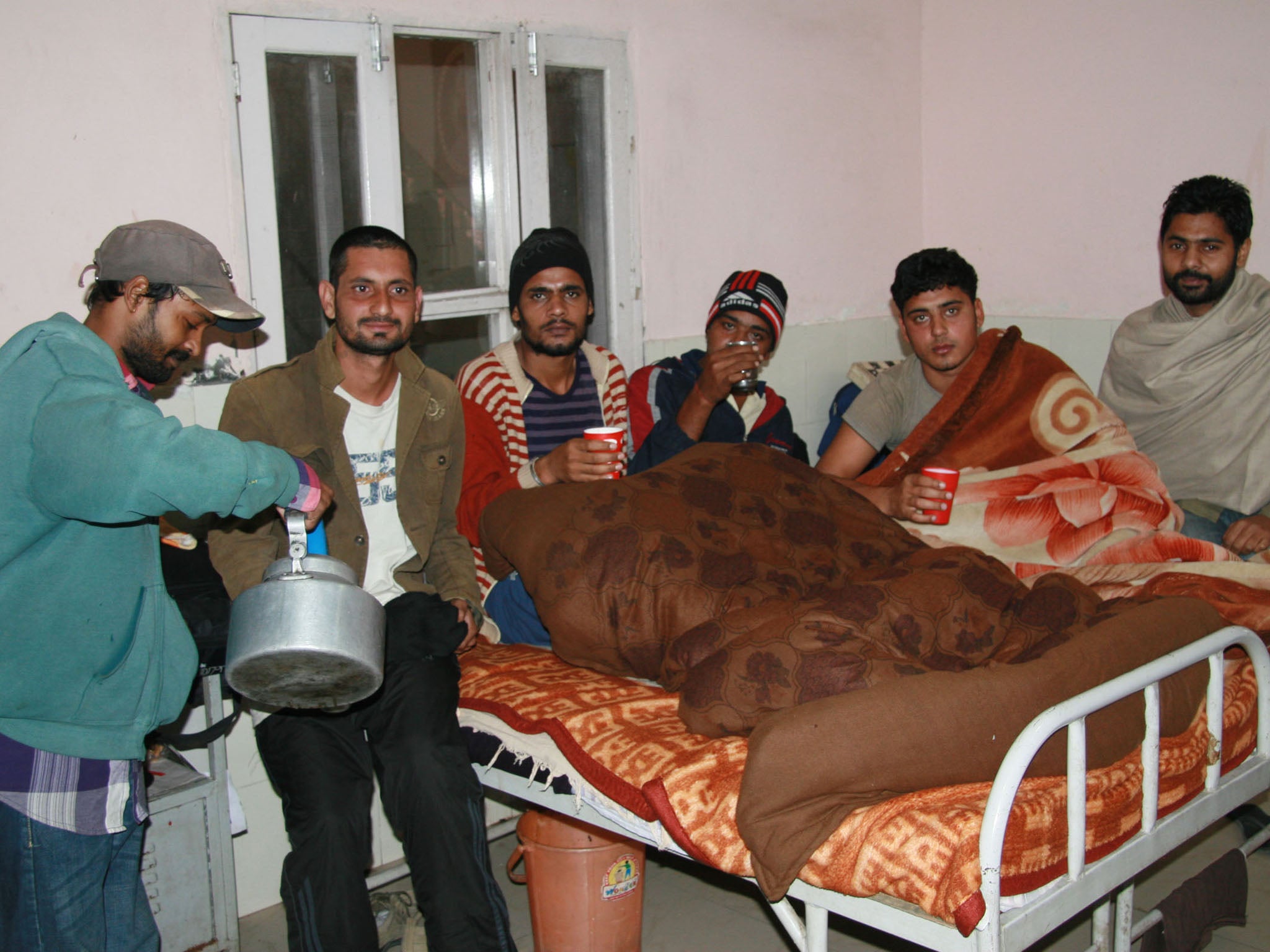Recovering drug addicts take tea and huddle under blankets in a de-addiction center in the northern Indian city of Tarn Taran Sahib