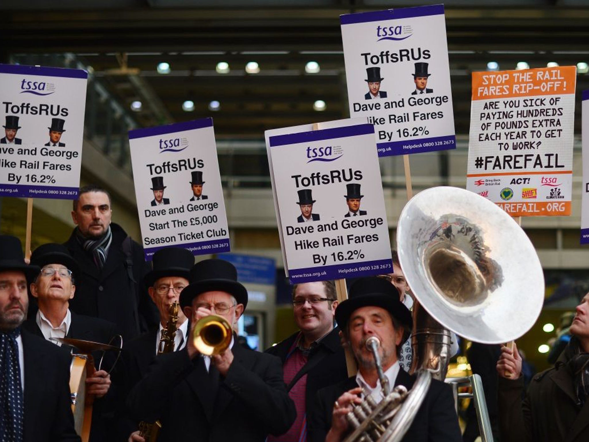 The ‘ToffsRUs’ jazz band play during a demonstration against a hike in rail fares at Kings Cross station in central London