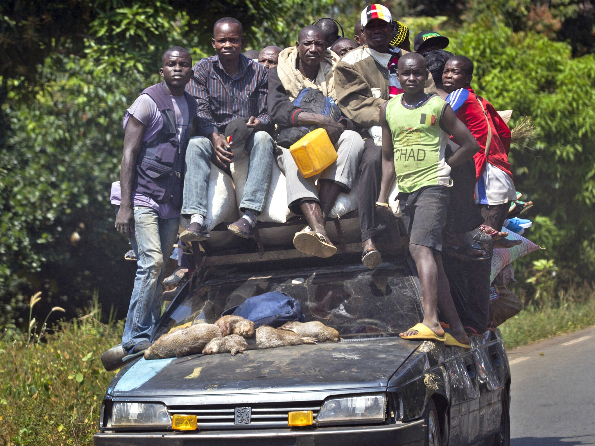 Passengers ride on a heavily laden car as they flee Damara, 70km north of the capital