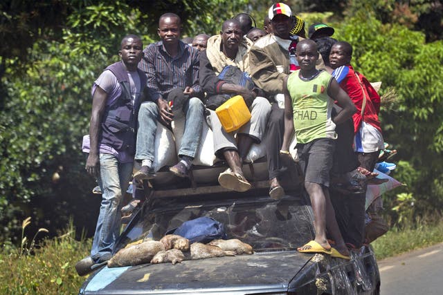 Passengers ride on a heavily laden car as they flee Damara, 70km north of the capital