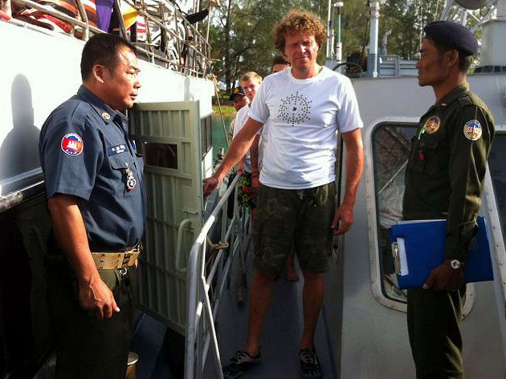Sergei Polonsky (centre) is led away by Cambodian officials 