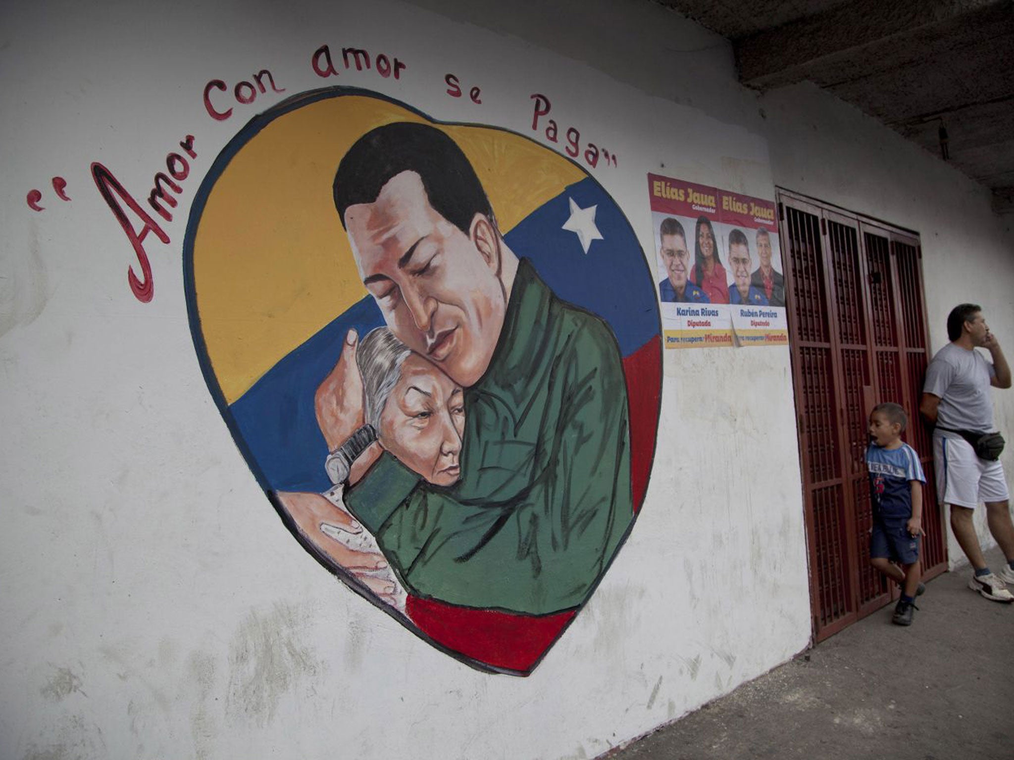 A heart-shaped mural shows an image of Venezuela's President Hugo Chavez hugging a woman, in Caracas