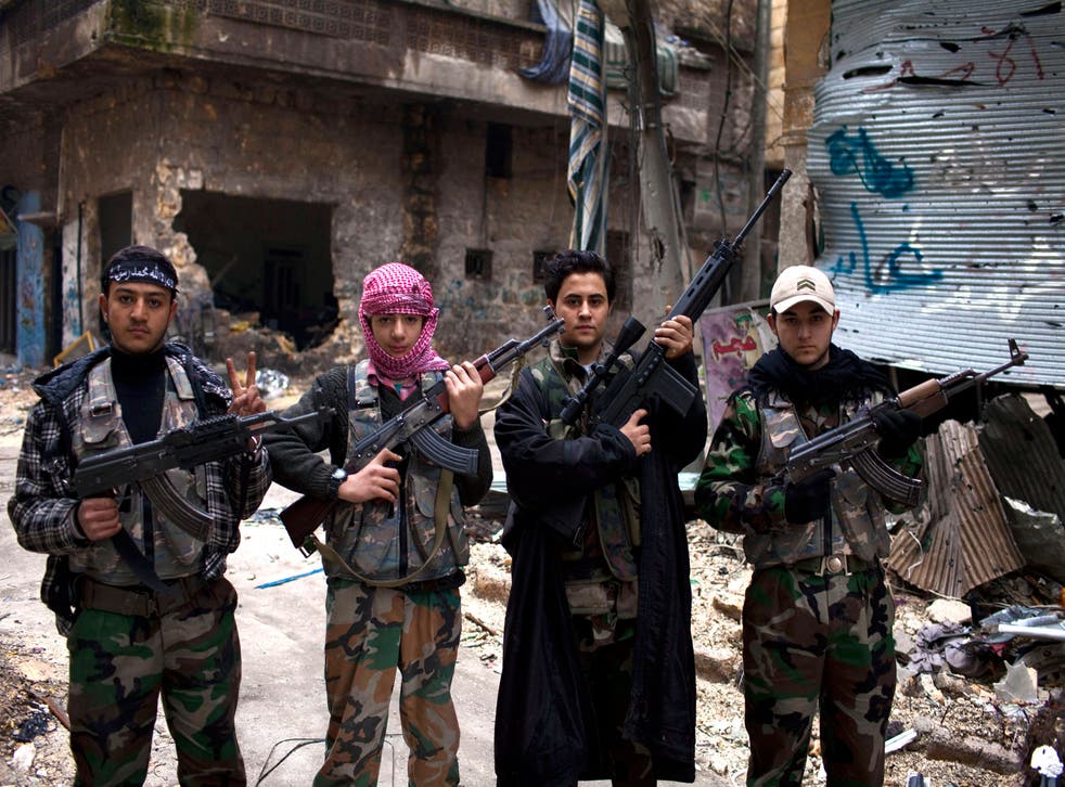 Syrian teenagers pose next to their checkpoint