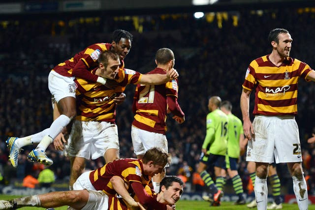 Bradford City's Irish defender Carl McHugh (bottom) celebrates with teammates after scoring the third goal