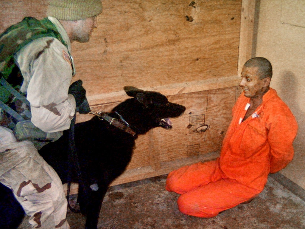 US soldier confronts an Iraqi detainee at Abu Ghraib in 2004