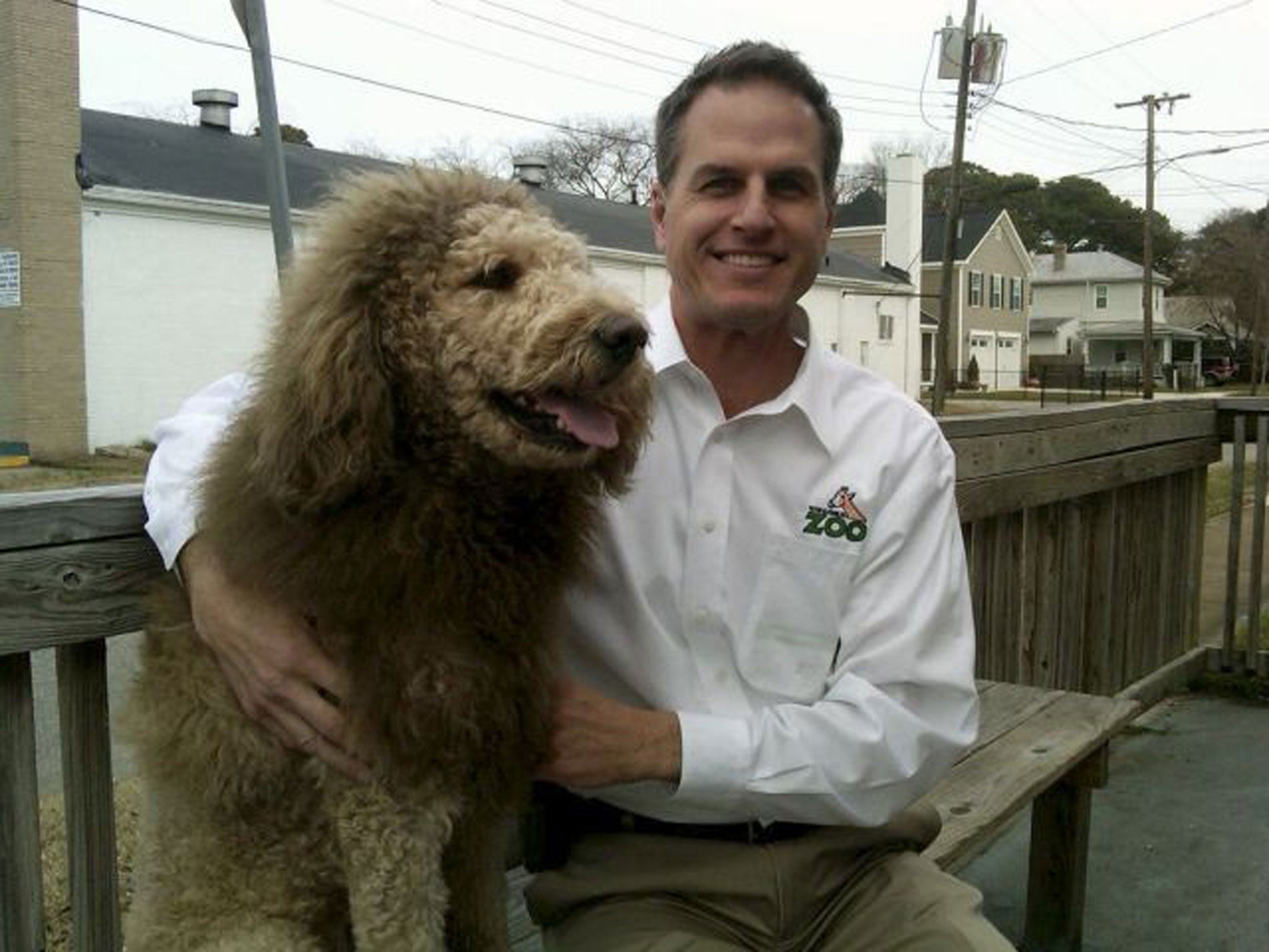 Virginia zoo's executive director Greg Brockheim with Charles the Monarch, a Labradoodle with a cut resembling the shaggy mane and tawny coat of a Lion