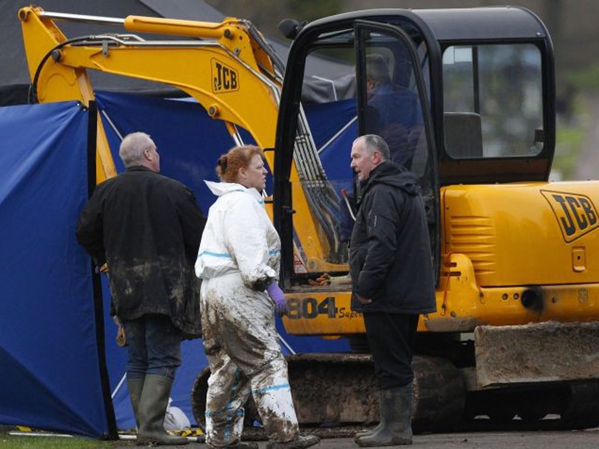 Forensic anthropologist Sue Black speaks with colleagues during the exhumation