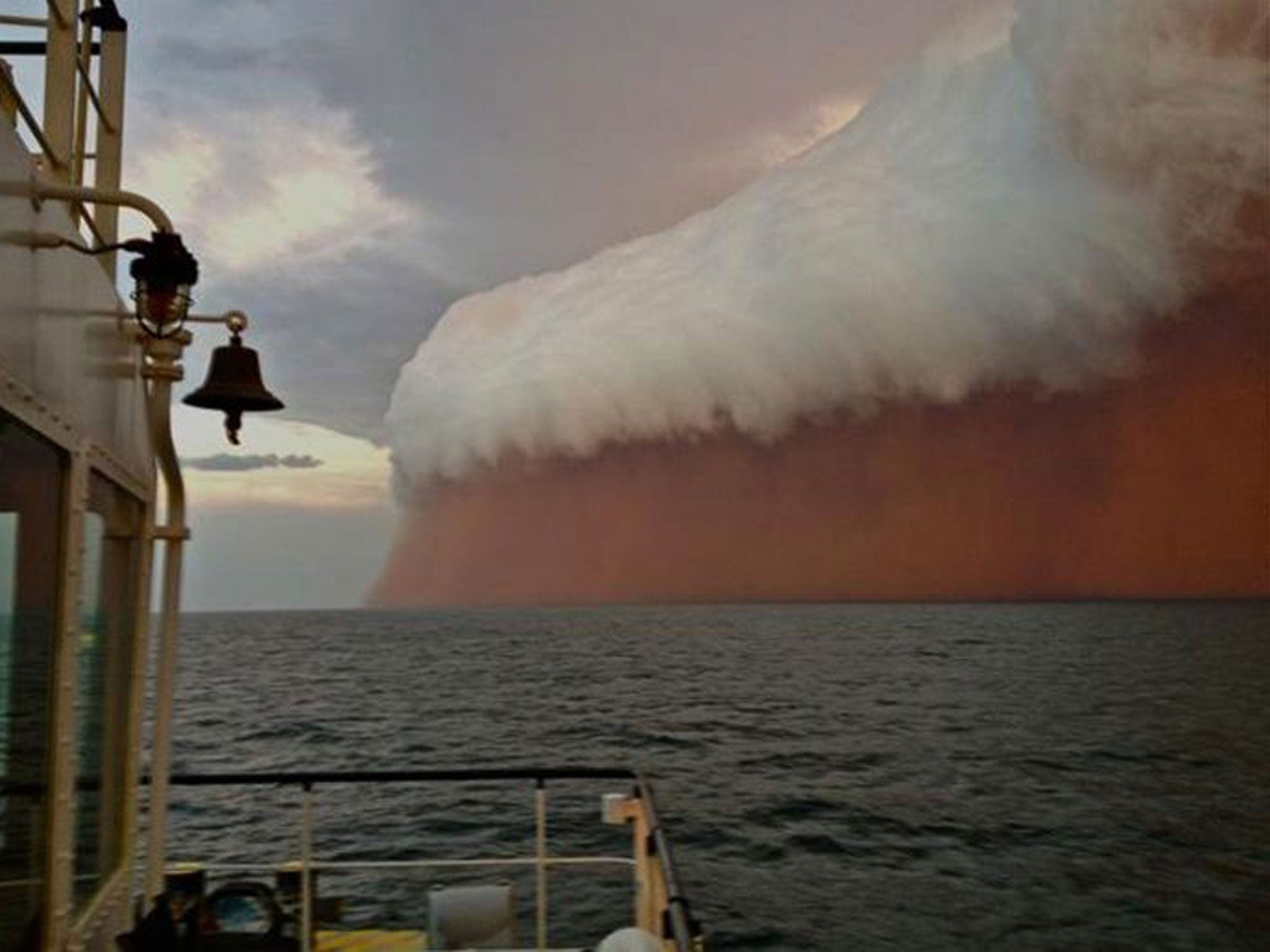 A towering red dust storm over the ocean ahead of the cyclone approaching Onslow on the West Australian coast