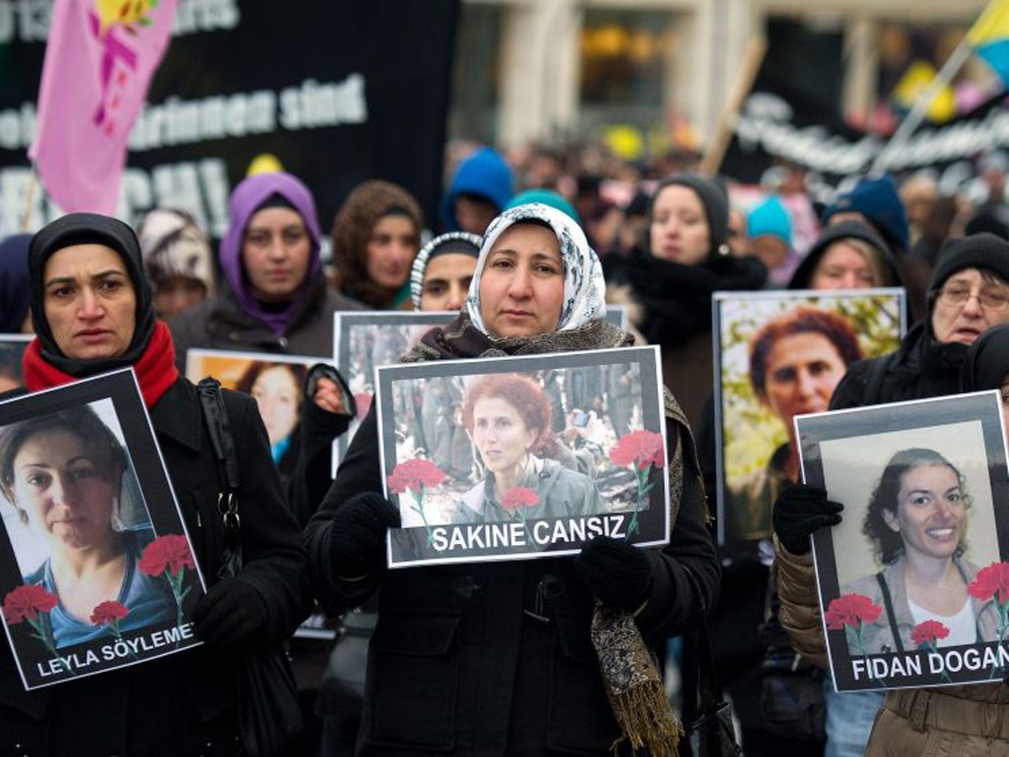Members of Kurdish organizations carry pictures of three murdered female Kurdish activists during a demonstration in Hamburg