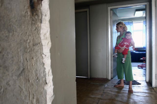 A Georgian woman from South Ossetia carries her baby on September 3, 2008 in an old Soviet-era Defense Ministry building in Tbilisi, where she found refuge.