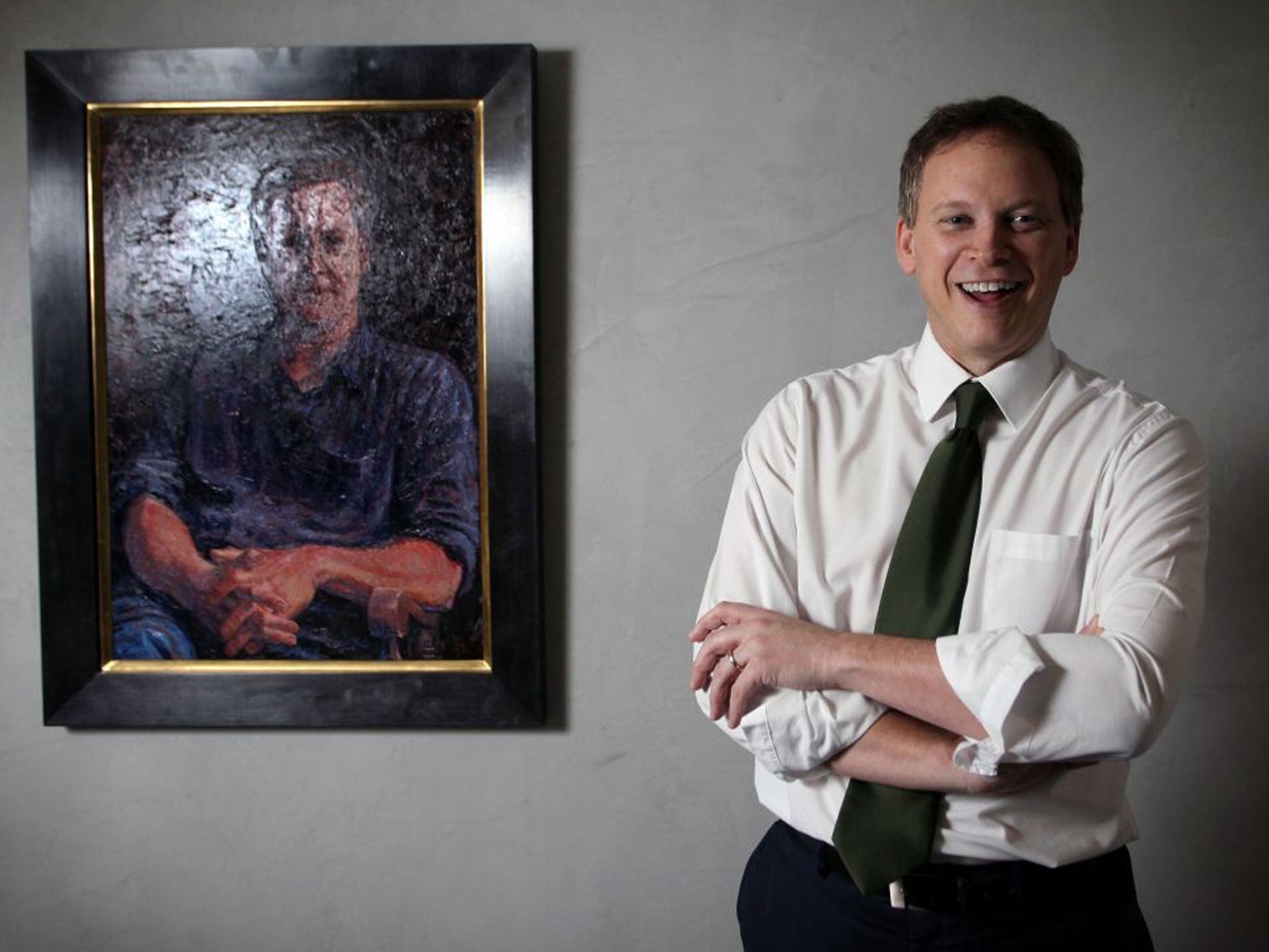 Grant Shapps, chairman of the Conservative Party, next to a portrait of David Cameron at the Conservative Party campaign headquarters