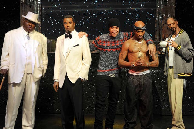 UK rap star 'Chip' (centre), gets a close up look at four US Rap stars that are together on display for the first time (left to right) Notorious B.I.G, P Diddy, Tupac Shakur, and Snoop Dog  which are now on display at the Madame Tussauds Waxworks in centr