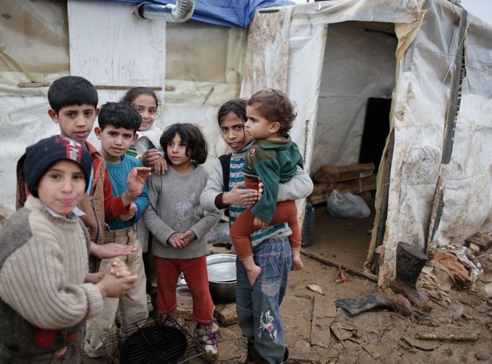 Young Syrian refugees gather around a small fire at the Minieh camp in Lebanon