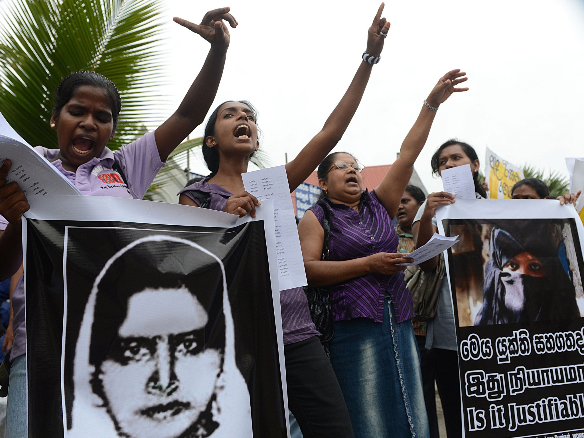 Sri Lankan activists hold up a portrait of Rizana Nafeek as they shout slogans during a protest in Colombo January 11, 2013, following her execution by Saudi authorities. Nafeek, convicted for murdering an infant under her care, was executed by Saudi Arabian authorities on Wednesday despite appeals for clemency from Sri Lankan President Mahinda Rajapaksa.