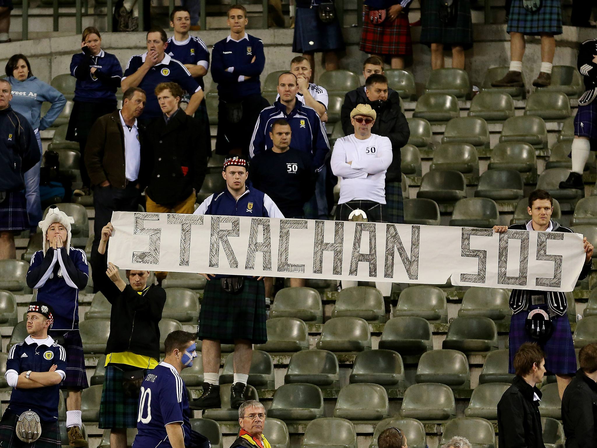 Scotland fans hold a sign asking for help from Gordan Strachan during the World Cup Qualifier match between Belgium last year