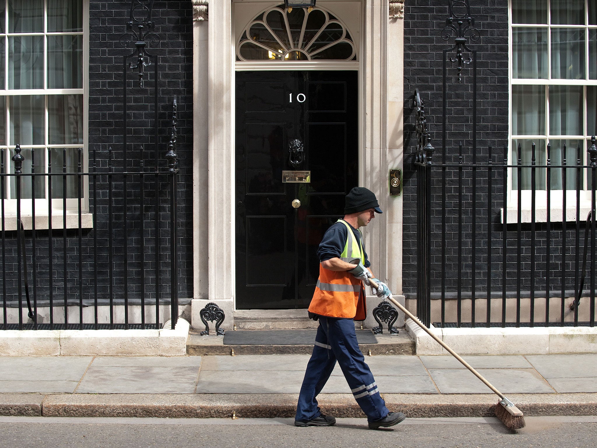 A street cleaner passes the front door of 10 Downing Street in London, on May 5, 2010, on the eve of a general election in Britain.