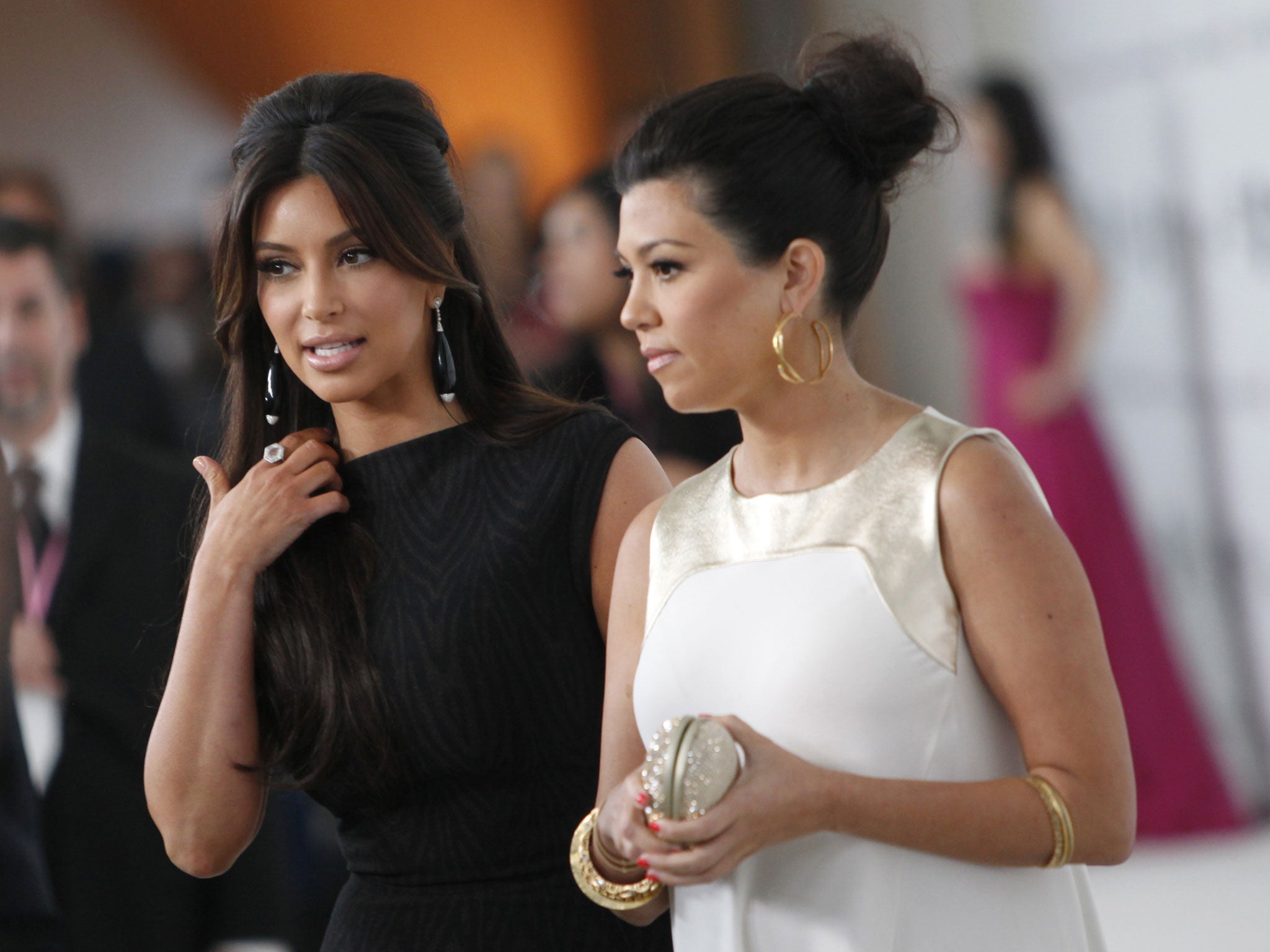 Kim (L) and Kourtney Kardashian arrive at the 20th Annual Elton John AIDS Foundation Academy Awards
