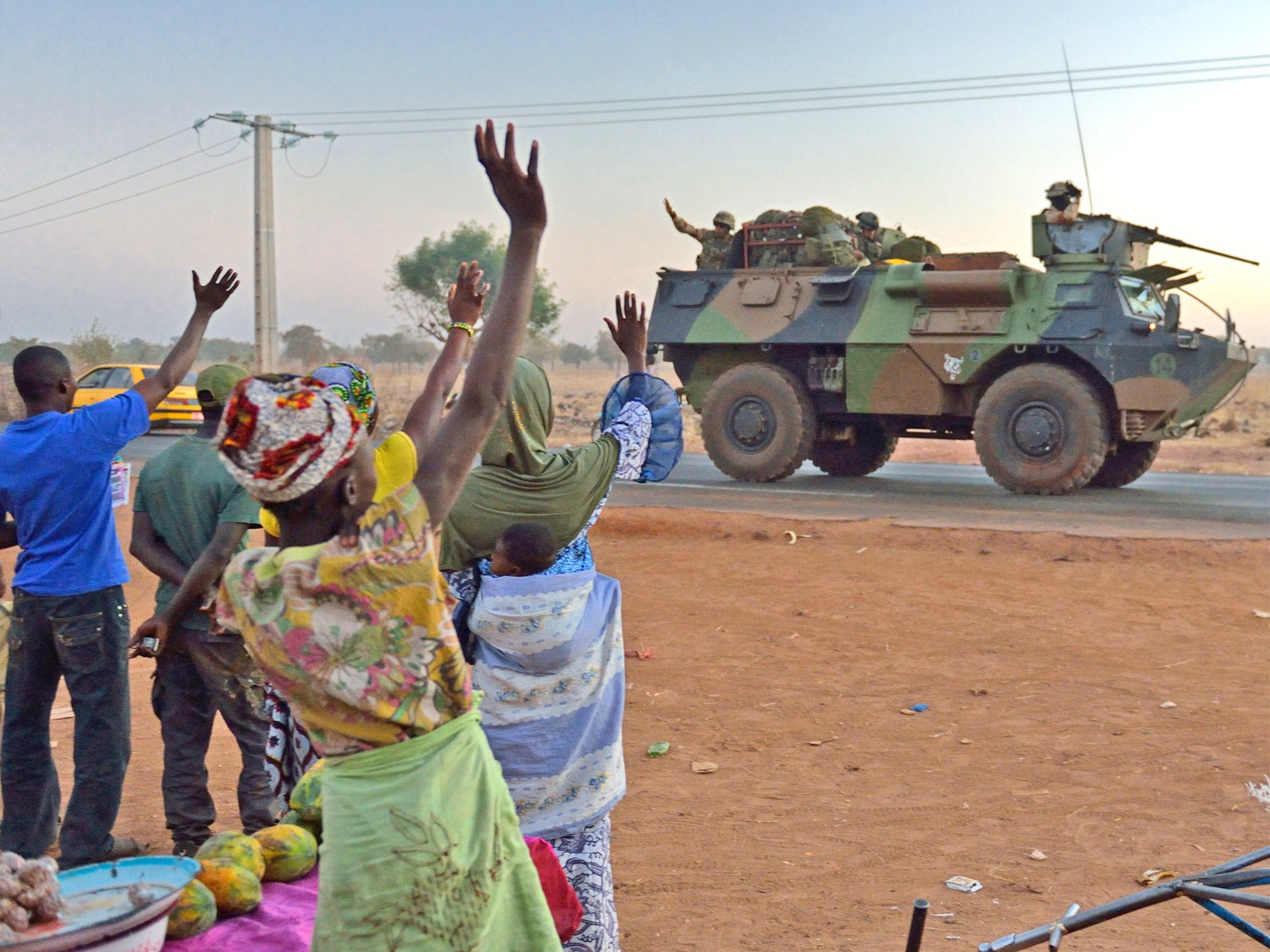 Malians wave to French soldiers as a convoy leaves Bamako. More troops and equipment were arriving yesterday
