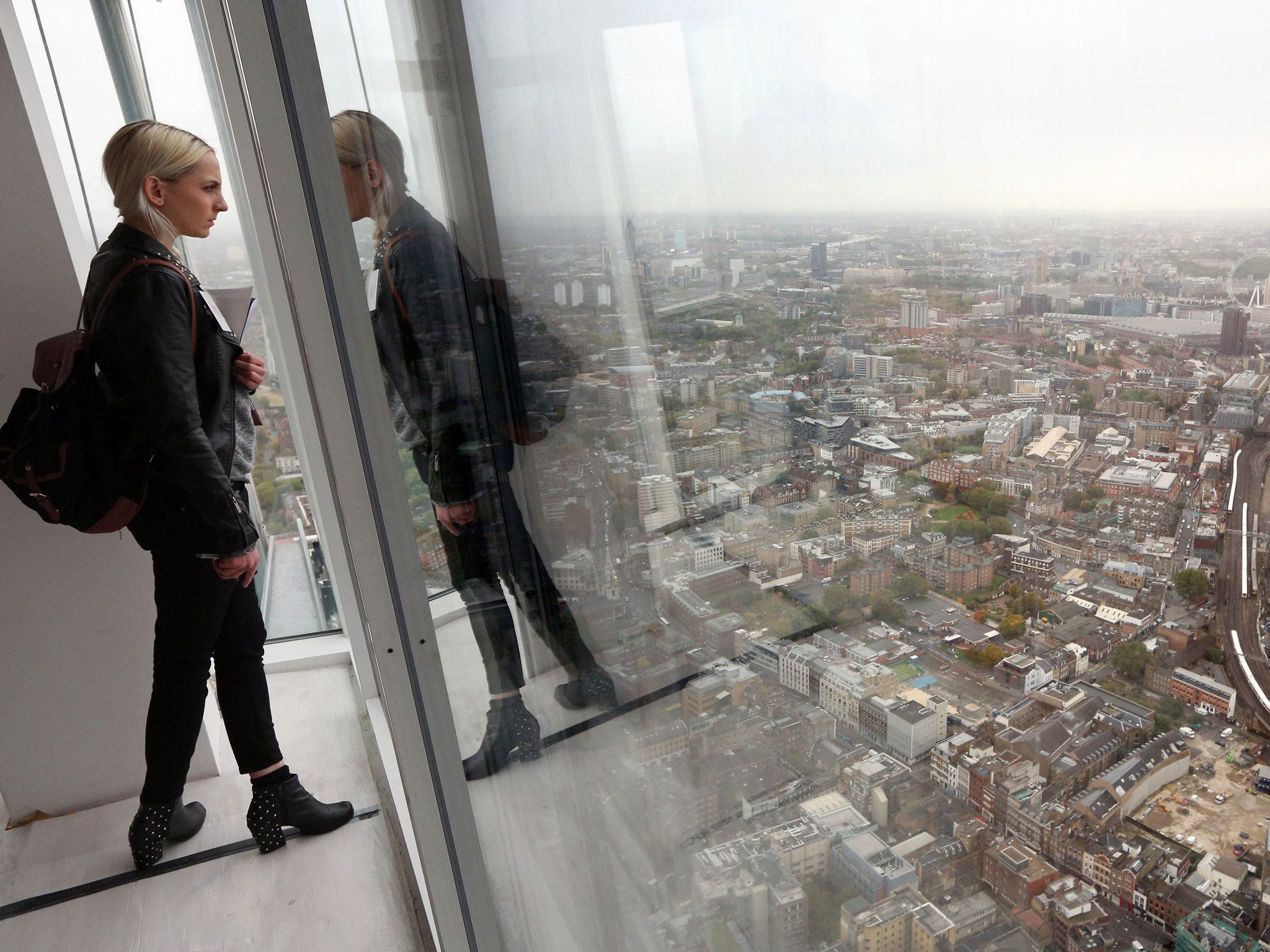 A woman admires the view from the 69th floor of The Shard skyscraper on the preview day to mark the sale of tickets for the 'View from The Shard' experience on October 26, 2012 in London, England.