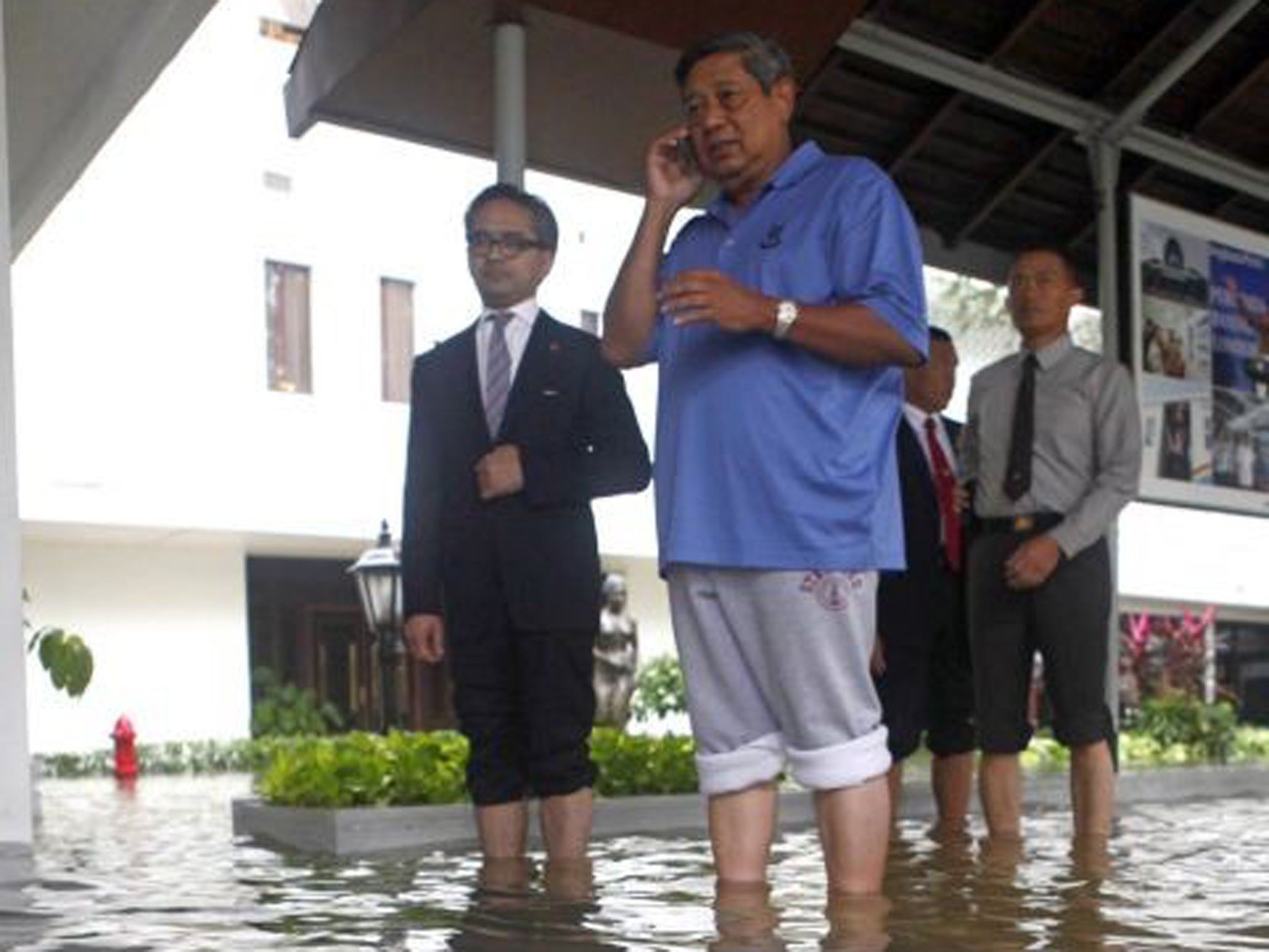 Indonesian president Susilo Bambang Yudhoyono, centre, inspects the flooded palace with foreign minister Marty Natalegawa, left, in Jakarta