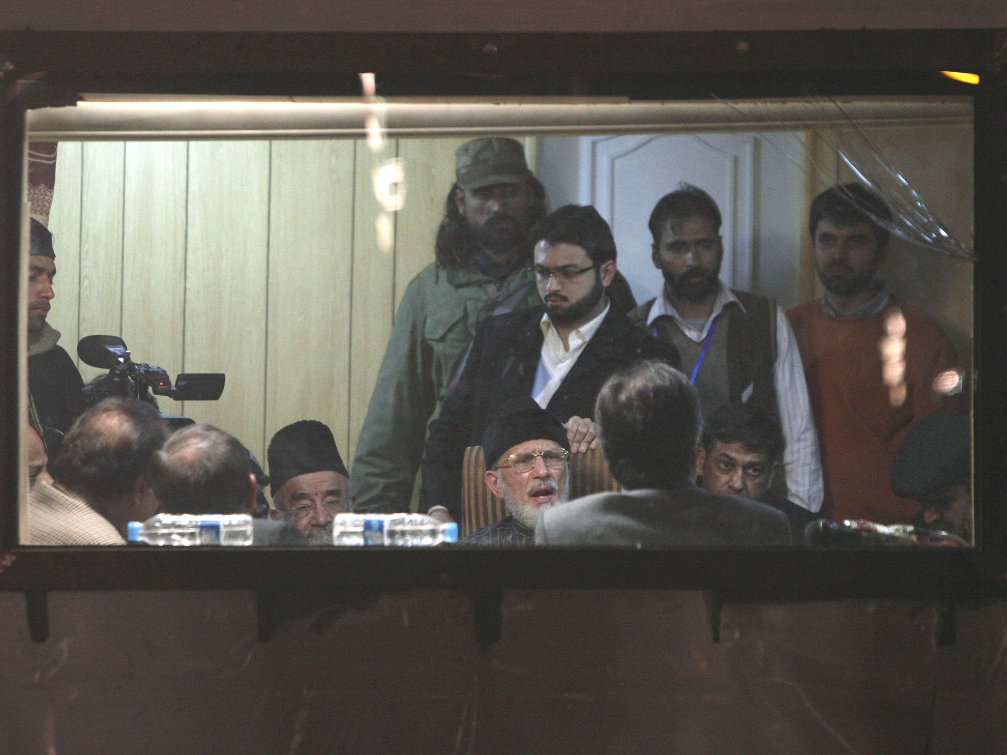Tahir ul Qadri (seated, centre) meets members of Pakistan’s coalition government in an armoured vehicle after four days of protest