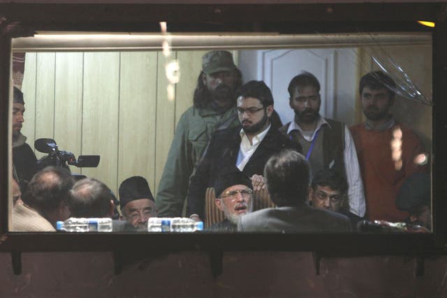 Tahir ul Qadri (seated, centre) meets members of Pakistan’s coalition government in an armoured vehicle after four days of protest 