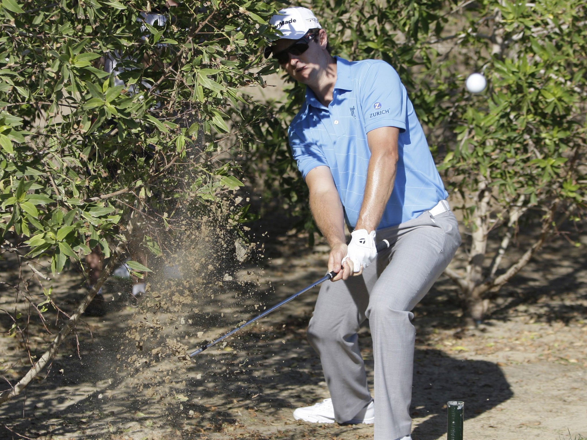 Bush whack: Justin Rose plays his way out of trouble in the trees on the 10th hole during his round of 68 yesterday