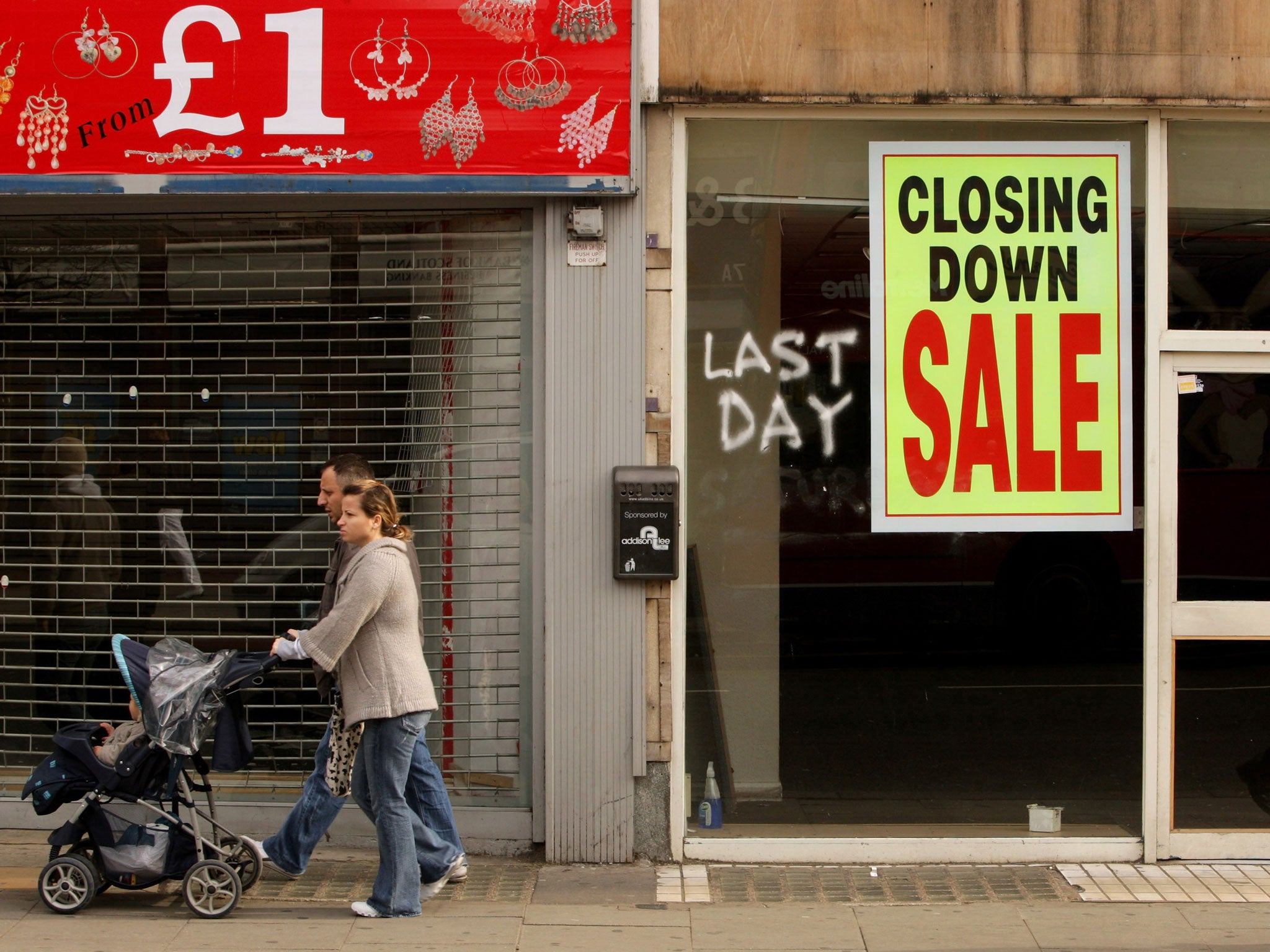 Members of the public walk past shops on Kilburn High Road on March 13, 2009 in London, England.