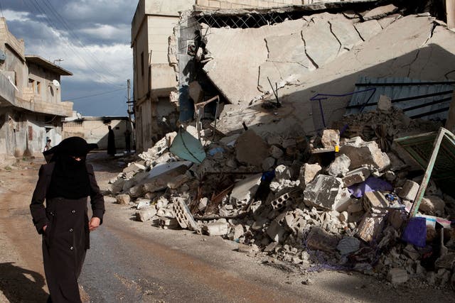 A Syrian woman walks past the rubble of homes allegedly destroyed during Syrian government army shelling in the town of Taftnaz, in northwestern Syria, on April 15, 2012.