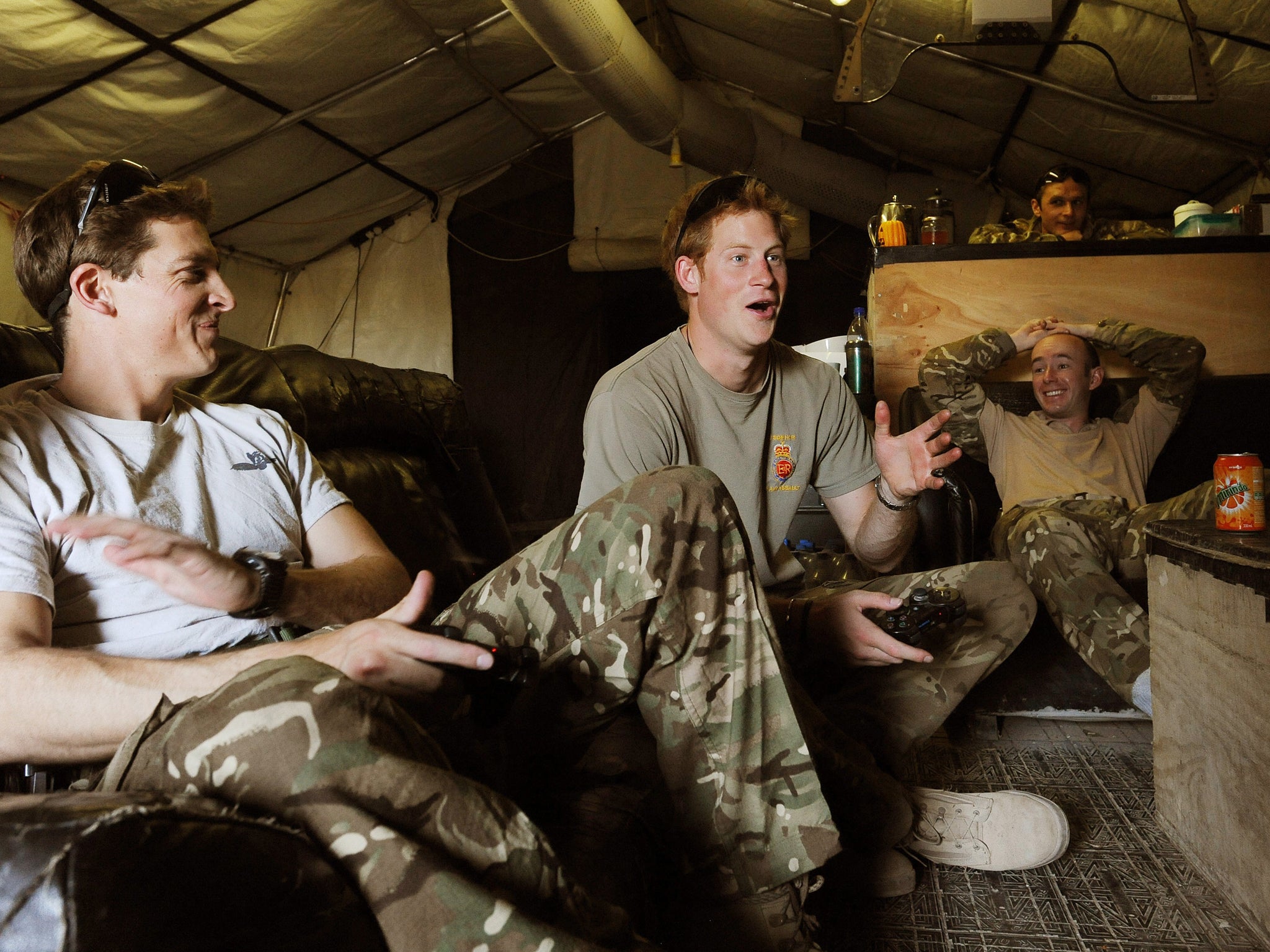 Prince Harry relaxes after scoring a goal during a computer football game with his fellow Apache Helicopter Pilot Capt Simon Beattie (left), during their 12 hour VHR (very high readiness) shift