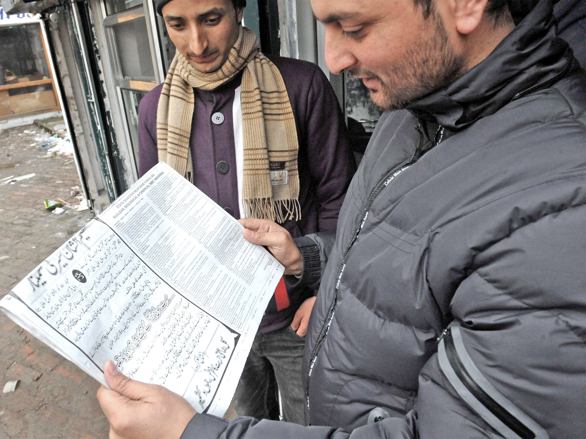 Kashmiri residents read the instructions