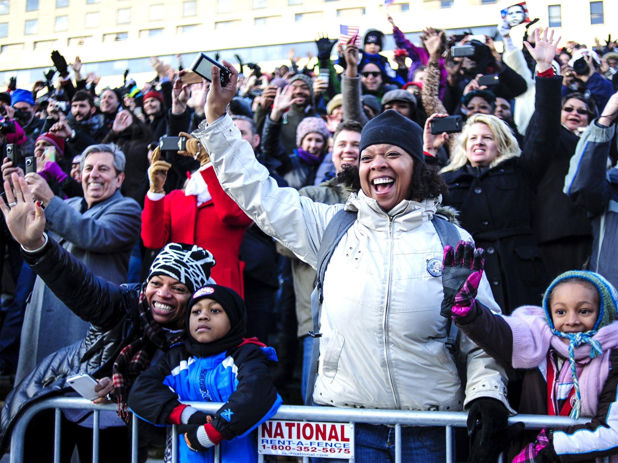 Spectators wave to President Barack Obama as the inaugural parade moves down Pennsylvainia Avenue
