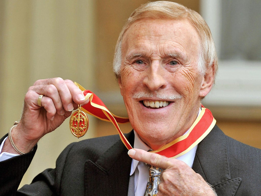 Bruce Forsyth poses for photographs after receiving his knighthood in 2011