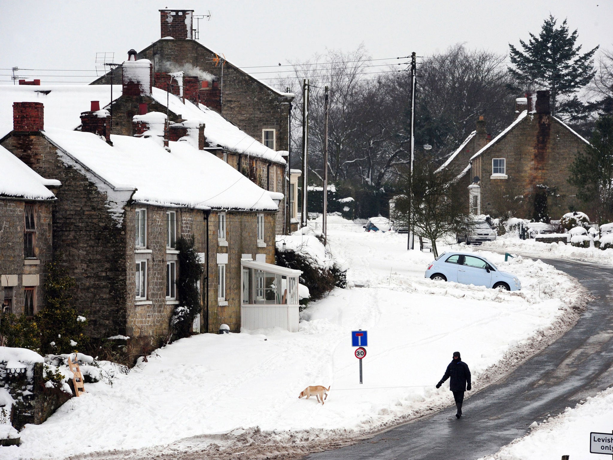 A man walks his dog in Lockton in North Yorkshire as the winter weather continues across the UK