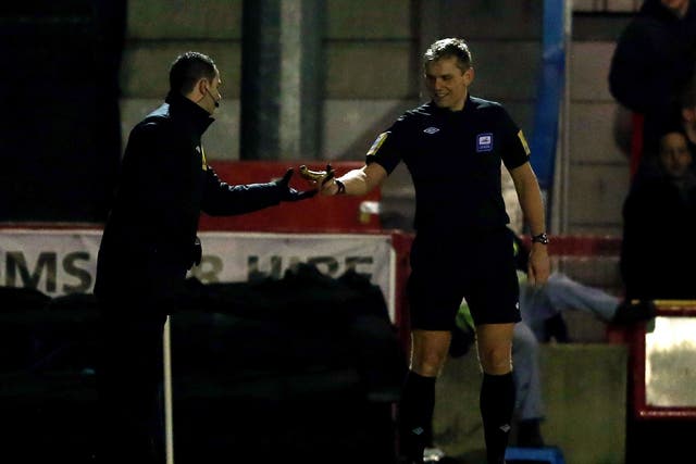 Referee Graham Scott removes a banana after being thrown on the pitch