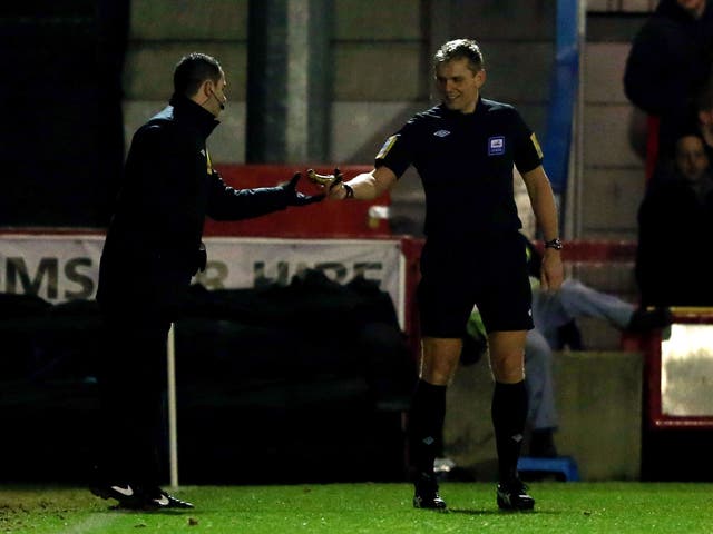 Referee Graham Scott removes a banana after being thrown on the pitch