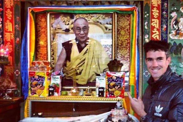 Kevin Pietersen poses in front of a picture of the Dalai Lama at the McLeod Ganj Buddhist Temple