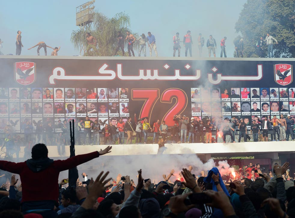 al-Ahly fans celebrate in front of a mural for the 72 of their fellow fans killed in the Port Said stadium disaster last year, as 21 al-Masry fans are sentenced to death for their parts in the riots