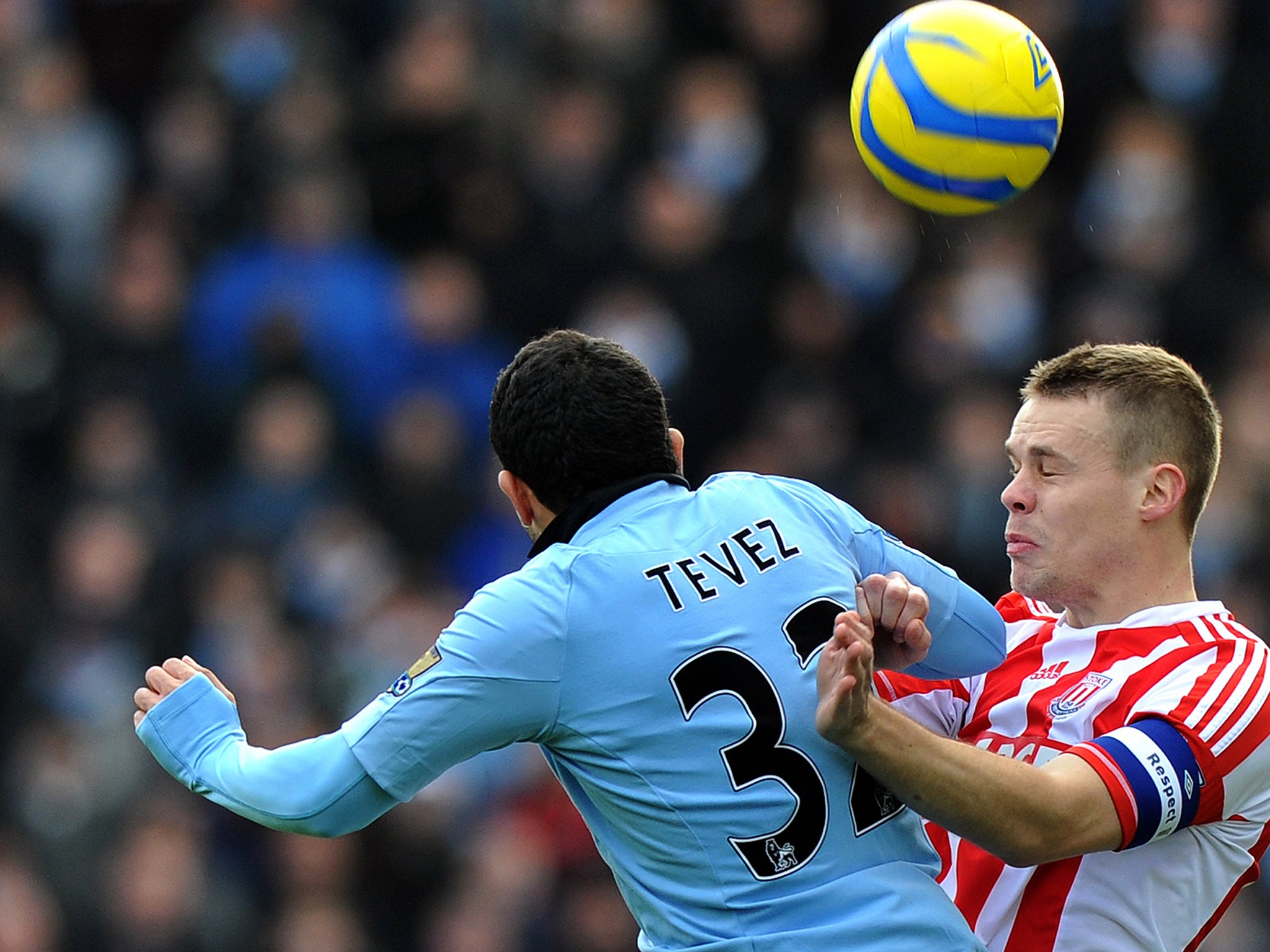 Manchester City's Carlos Tevez tussles with Stoke's Ryan Shawcross for the ball