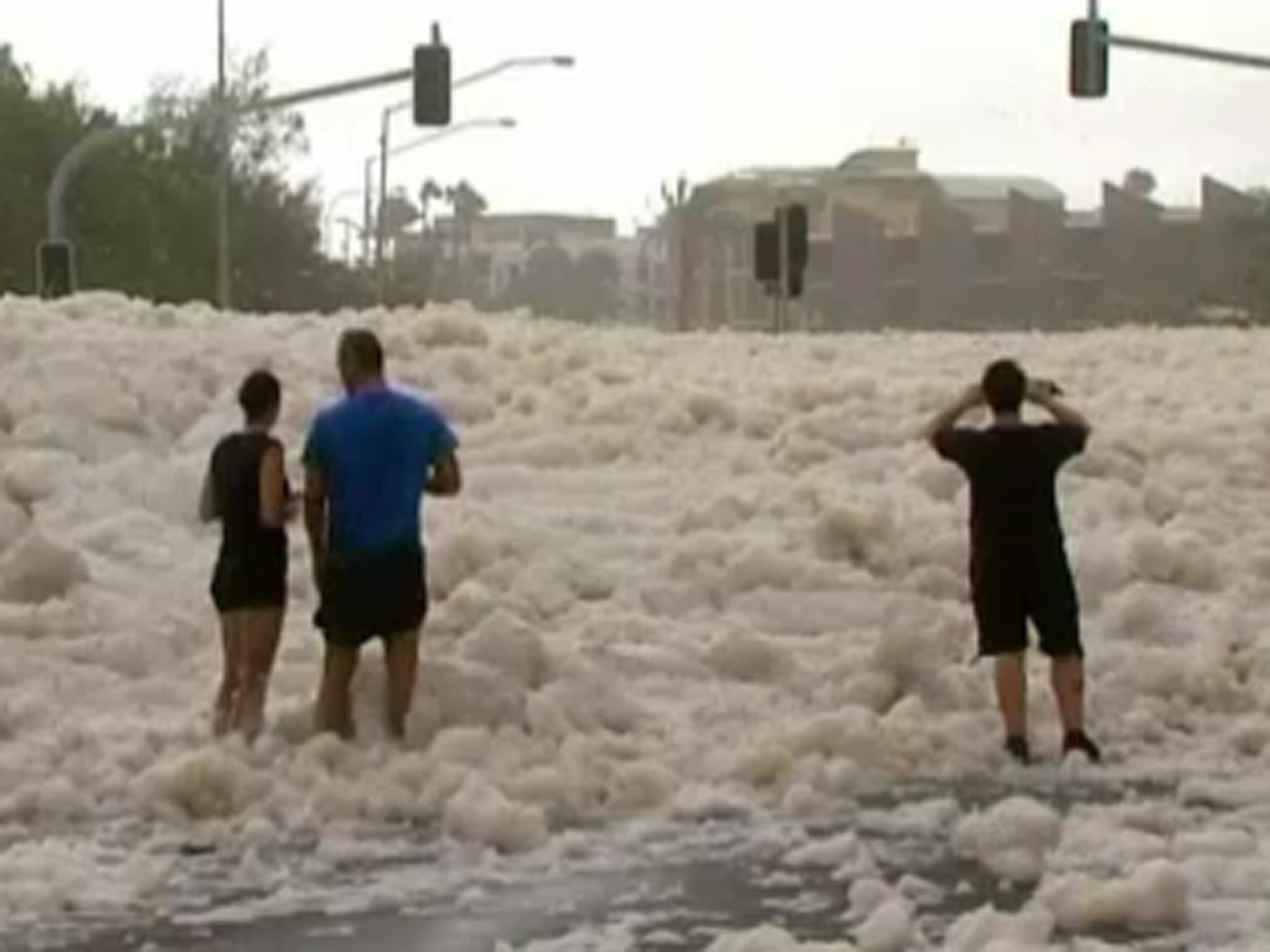Residents look at the foam-covered streets