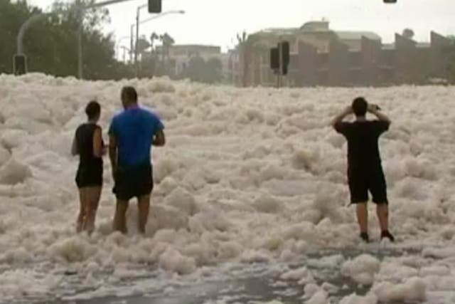 Residents look at the foam-covered streets