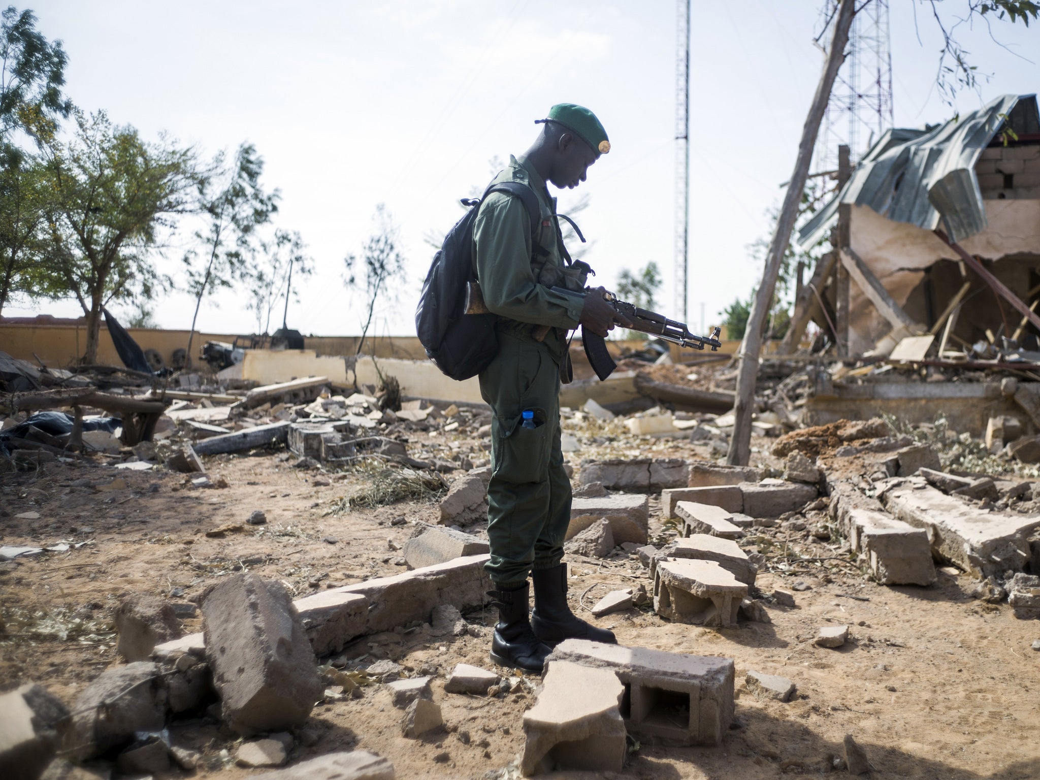 A Malian soldier stands in a destroyed area in the key central town of Konna now controlled by French and Malian army