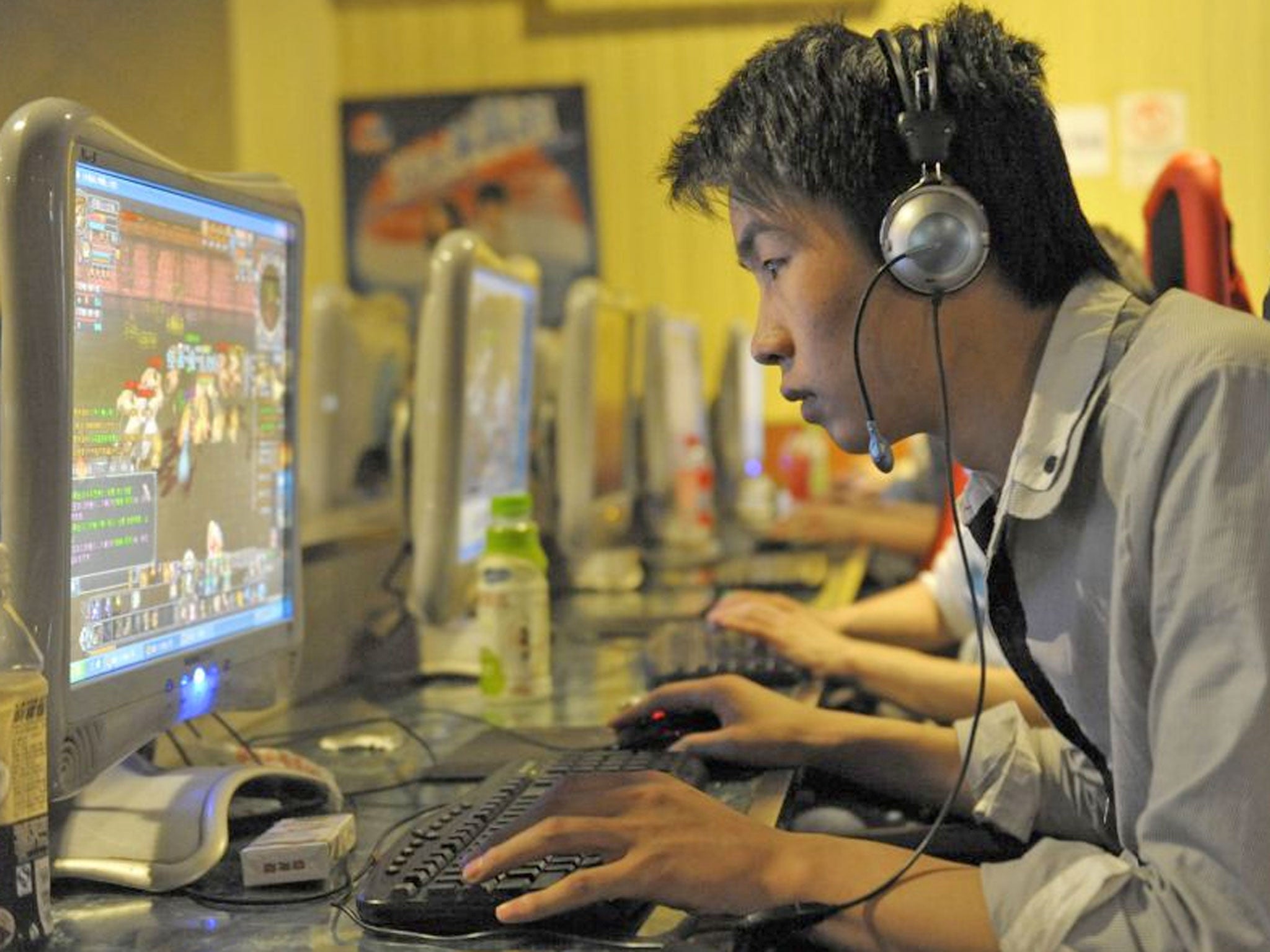 A chinese man plays online games at an internet cafe in Beijing