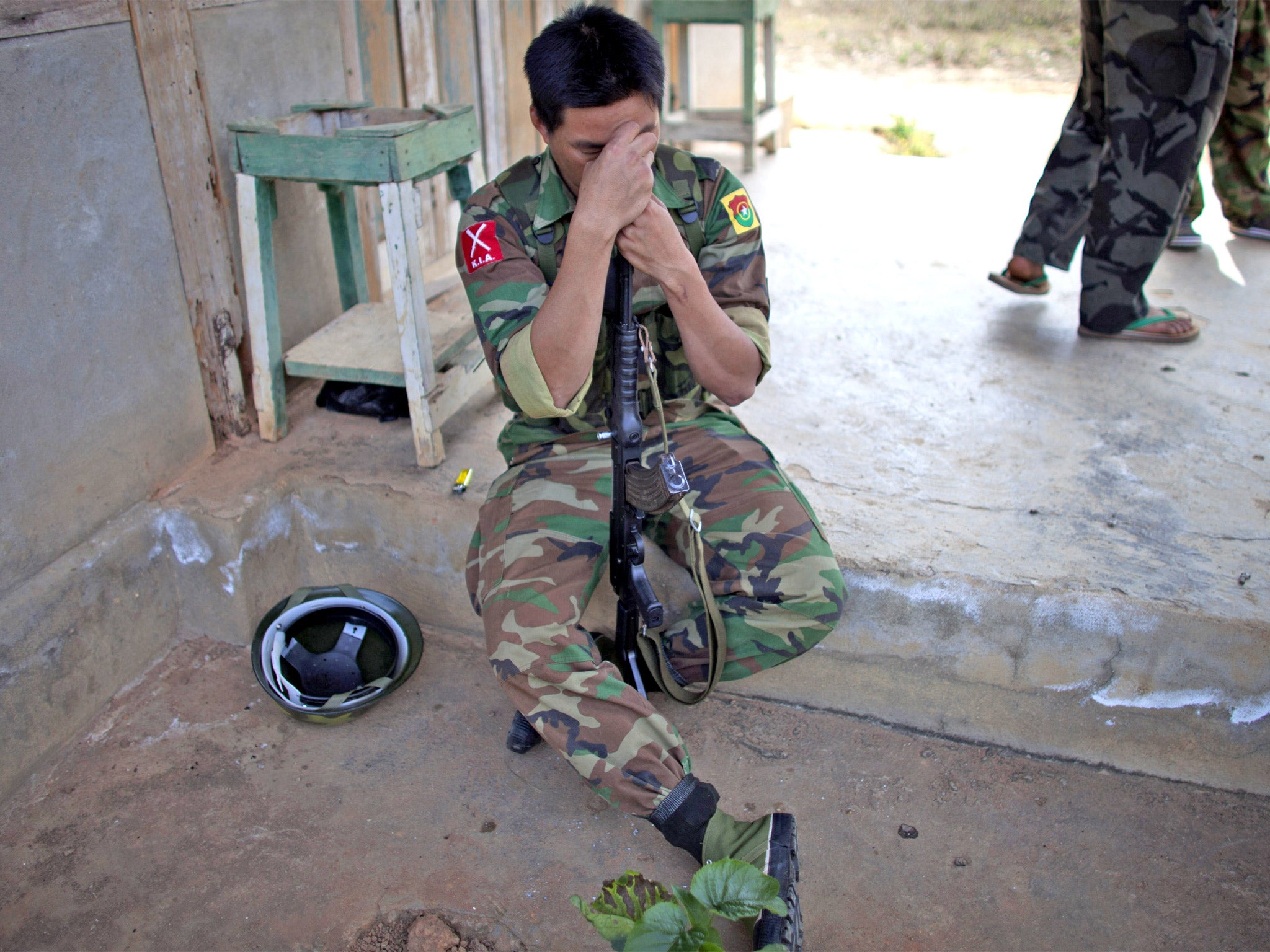 A Kachin soldier rests on his gun amid a lull in fighting yesterday
