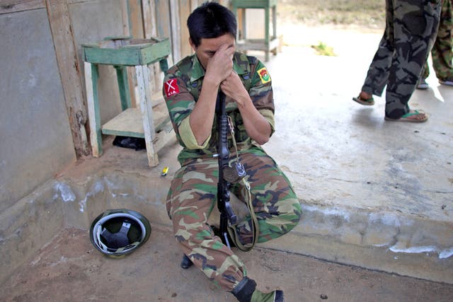 A Kachin soldier rests on his gun amid a lull in fighting yesterday
