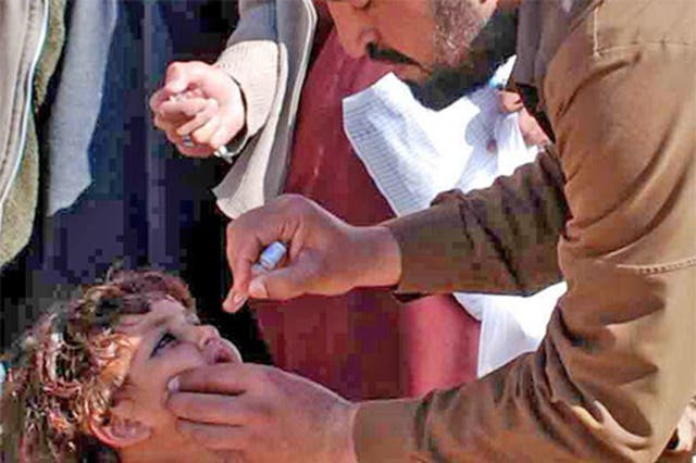 A vaccinator inoculates a child against polio in Pakistan