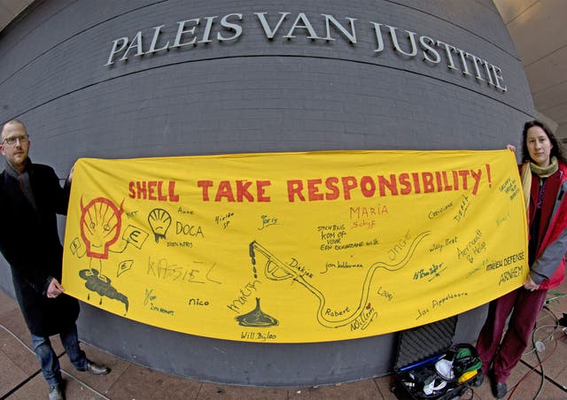 Friends of the Earth activists hold a banner outside the court in The Hague