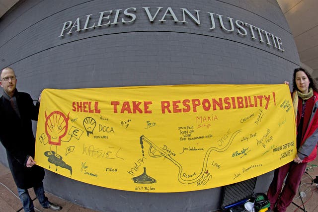 Friends of the Earth activists hold a banner outside the court in The Hague