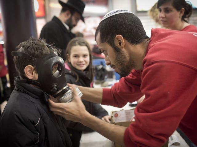 Civilians at a post office try out gas masks that were handed out in Haifa yesterday