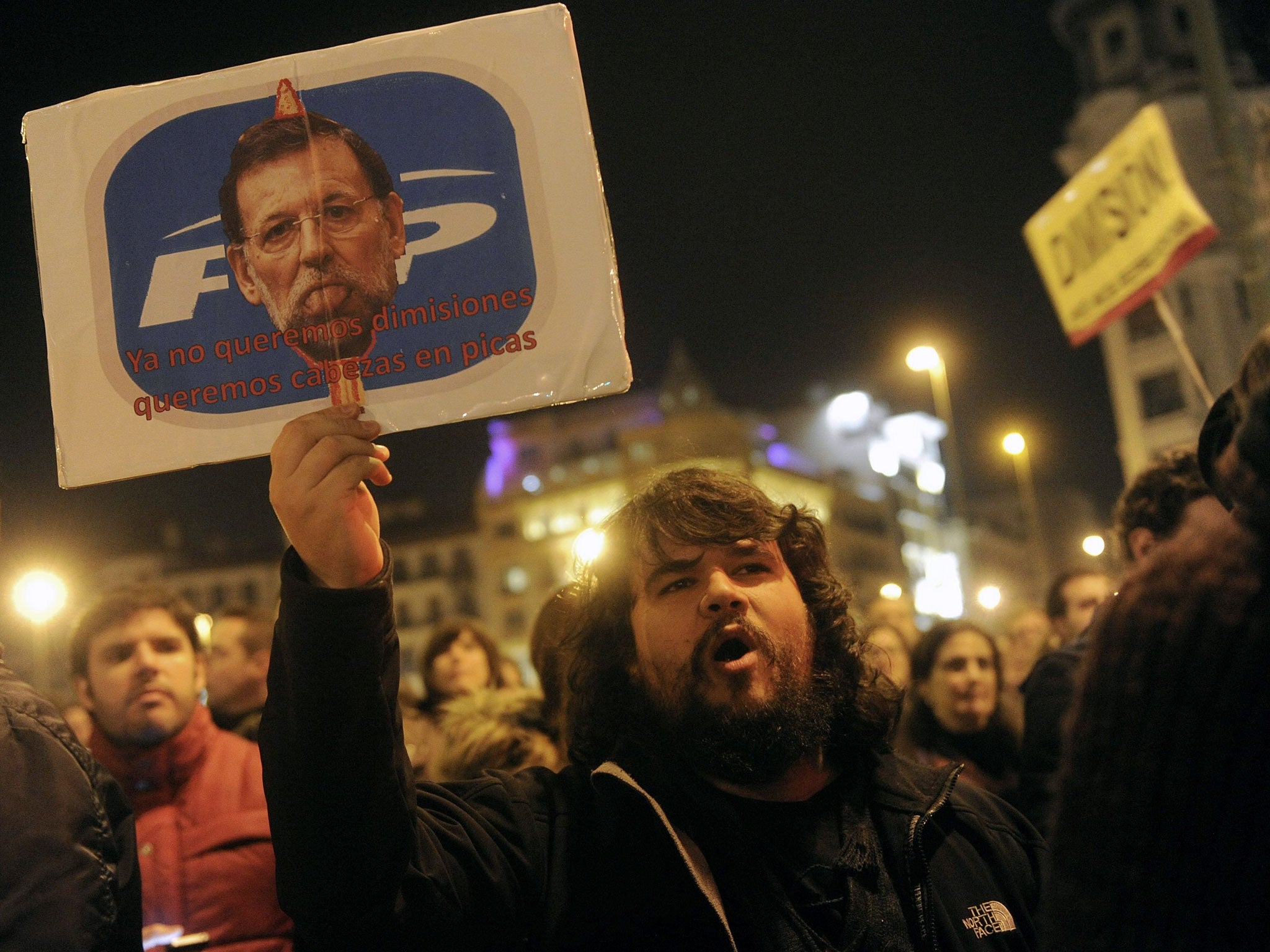January 31, 2013: A man holds a placard depicting Spanish Prime Minister Mariano Rajoy and reading "We don't even want resignations, we want heads on spike" as he takes part in a demonstration against corruption scandals implicating the PP (Popular Party